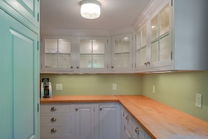 A kitchen with white cabinets, a coffee maker, and a wooden countertop. - Marlboro Escape: 9 Mi to Mount Snow Resort! (Wilmington)