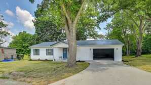 A single-story house with a garage, surrounded by trees and a well-maintained lawn. - Serene Dry Ridge Vacation Rental w/ Nearby Fishing (Dry Ridge)