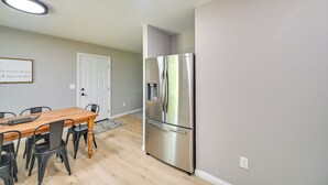 A modern kitchen with a stainless steel refrigerator, wooden dining table, and black chairs. - Serene Dry Ridge Vacation Rental w/ Nearby Fishing (Dry Ridge)