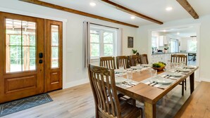 Un coin repas avec une table en bois dressée pour six personnes, entourée de chaises en bois.