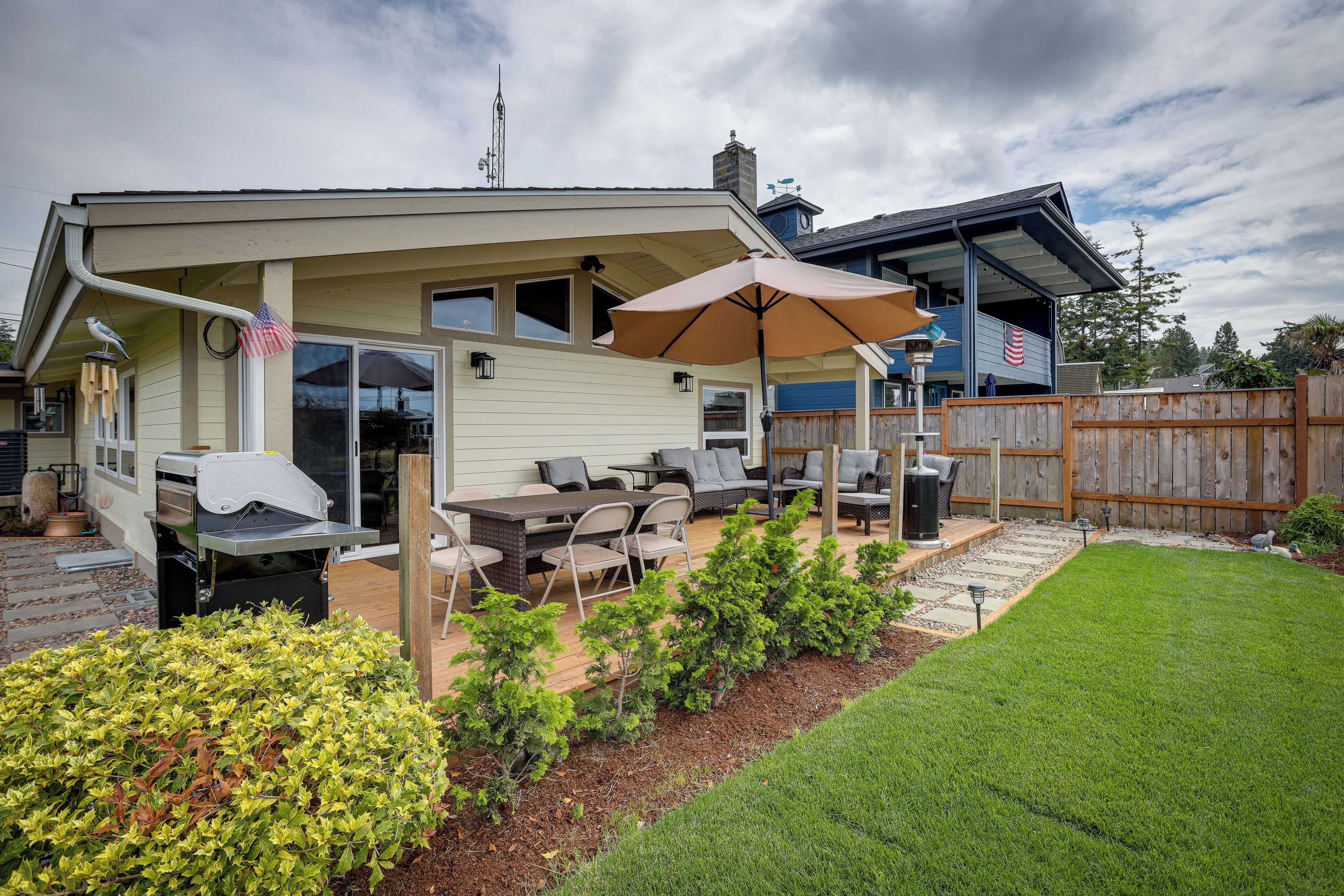 Ein Garten mit Terrasse, Gartenmöbeln und Grill.