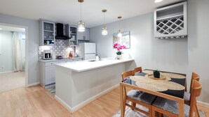 Une cuisine moderne avec un îlot central, des chaises en bois et des luminaires suspendus.