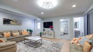 Un salon moderne avec un canapé, une table basse et un téléviseur.