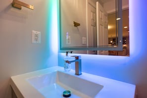 A modern bathroom with a white sink, a large mirror, and a faucet. - Cozy Herndon Home Near Wineries! (Herndon)