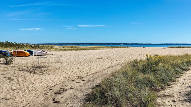 Ein Sandstrand mit mehreren Booten, die links am Strand liegen.