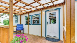 A covered porch with a wooden deck, a blue chair, and a welcome sign. - Northeast Texas Vacation Rental ~ 6 Mi to Commerce (Commerce)