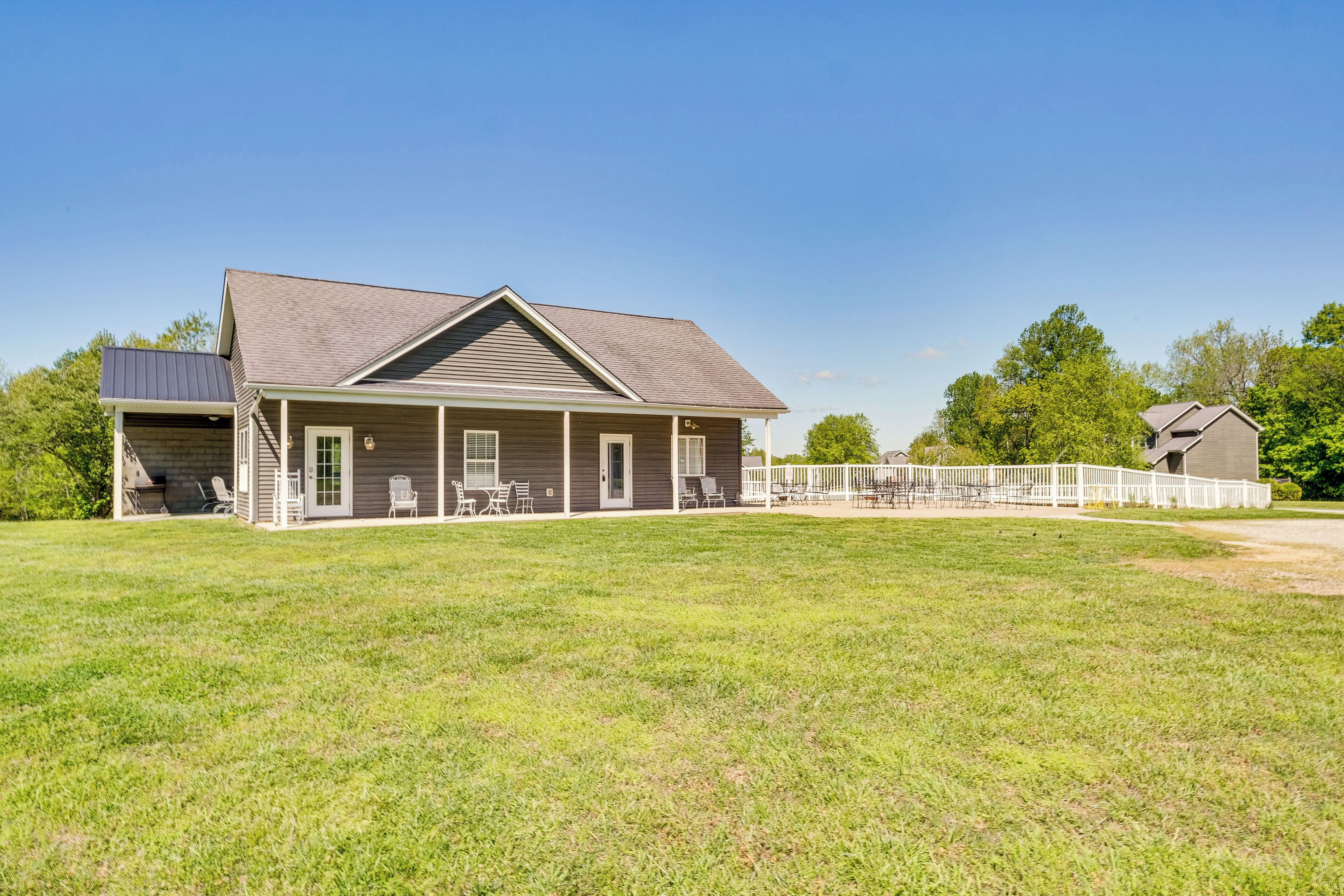 A two-story house with a covered porch, a fenced backyard, and a small detached garage.