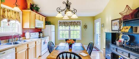 A kitchen with wooden cabinets, a dining table, and a chandelier.