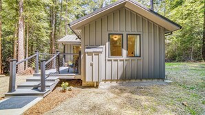 Une petite cabane dotée d’une véranda, d’un escalier et d’une balustrade.