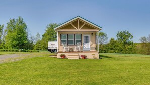 A small, single-story house with a porch, two windows, and a door. - Cozy New York Abode - Porch, Near Fishing & Hiking (Jordan)