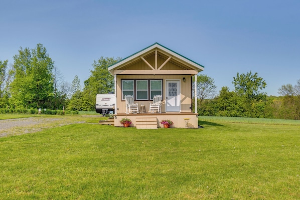 A small, single-story house with a porch, two windows, and a door. - Cozy New York Abode - Porch, Near Fishing & Hiking (Jordan)