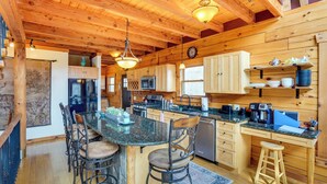 A wooden cabin interior with a kitchen, dining area, and a large wooden ceiling. - Berkshire Hills Nature Lovers' Log Home Retreat (Windsor)
