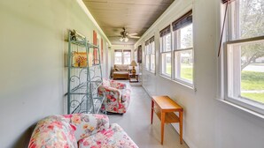 A hallway with a sofa, a wooden table, and a metal rack. - Vacation Rental Near South Dakota State University (Aurora)