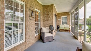 A covered porch with a wicker chair, a fan, and a sofa. - Muscle Shoals Home < 3 Mi to Recording Studios! (Muscle Shoals)