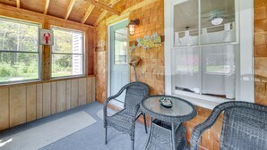 A wooden cabin with a porch, wicker chairs, a small table, and a welcome sign. - Georgetown Vacation Rental: Gas Grill & Near Beach (Georgetown)