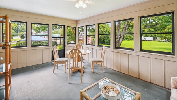 A sunroom with large windows, a ceiling fan, and a dining area with chairs and a table. - 6 Mi to Beach: Myrtle Beach Escape w/ Sunroom! (Myrtle Beach)