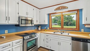 A kitchen with white cabinets, a stainless steel microwave, a stove, and a dishwasher. - 6 Mi to Beach: Myrtle Beach Escape w/ Sunroom! (Myrtle Beach)