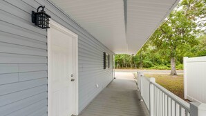 A covered porch with a white door, a black lantern, and a doormat. - Walk to Atlantic Beach: Family Gem w/ Fenced Yard (North Myrtle Beach)