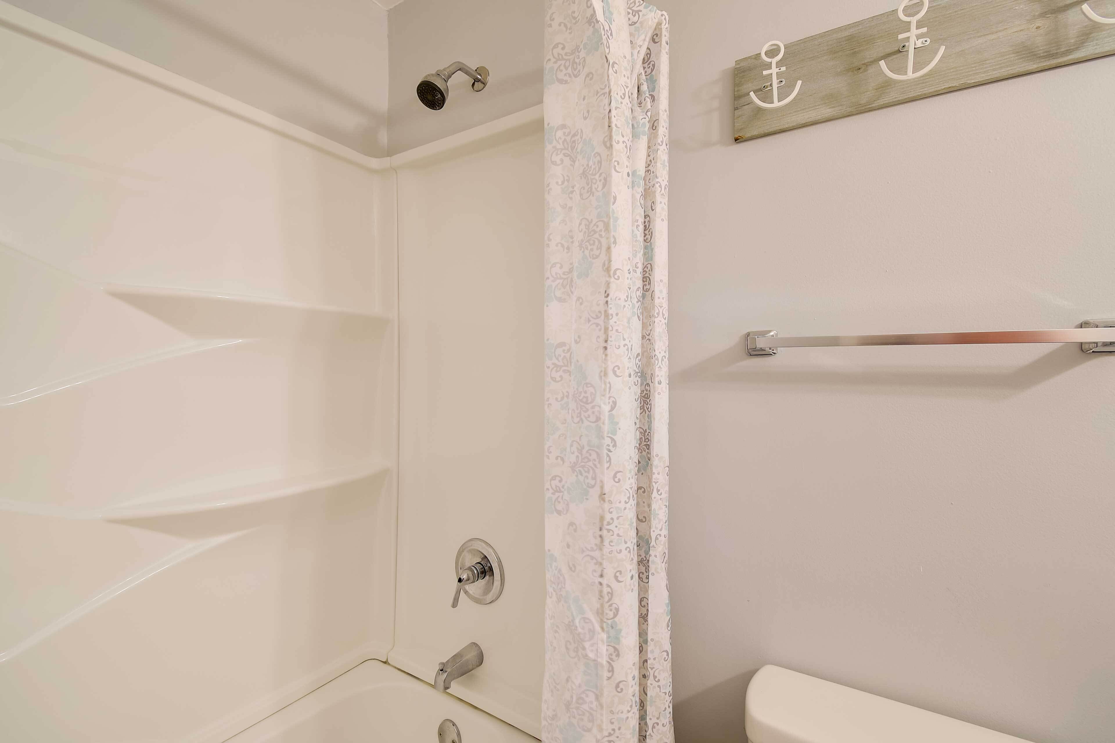 Une salle de bain équipée d’une douche, de toilettes et d’un porte-serviettes.