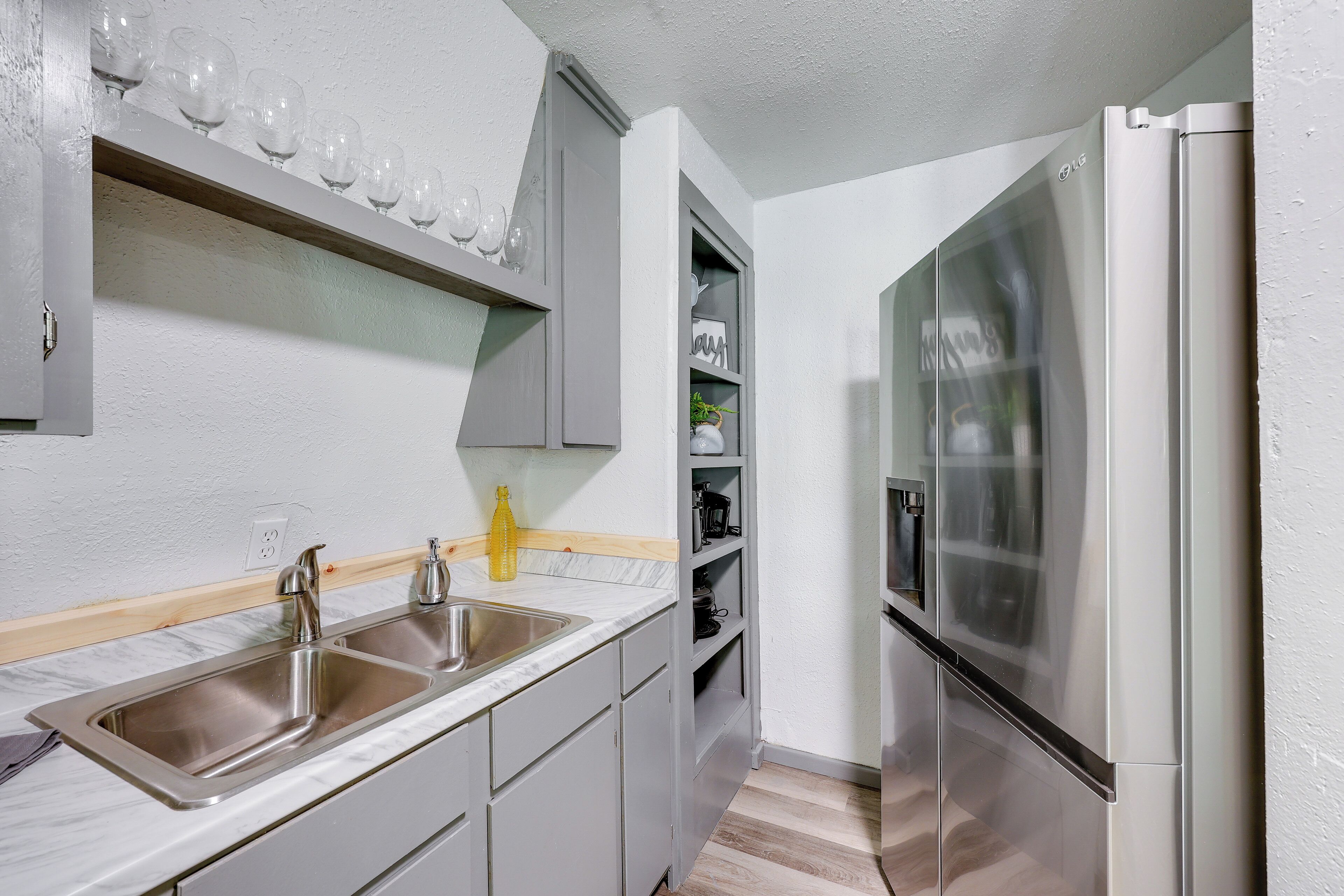 A modern kitchen with stainless steel appliances, a double sink, and a built-in wine rack.