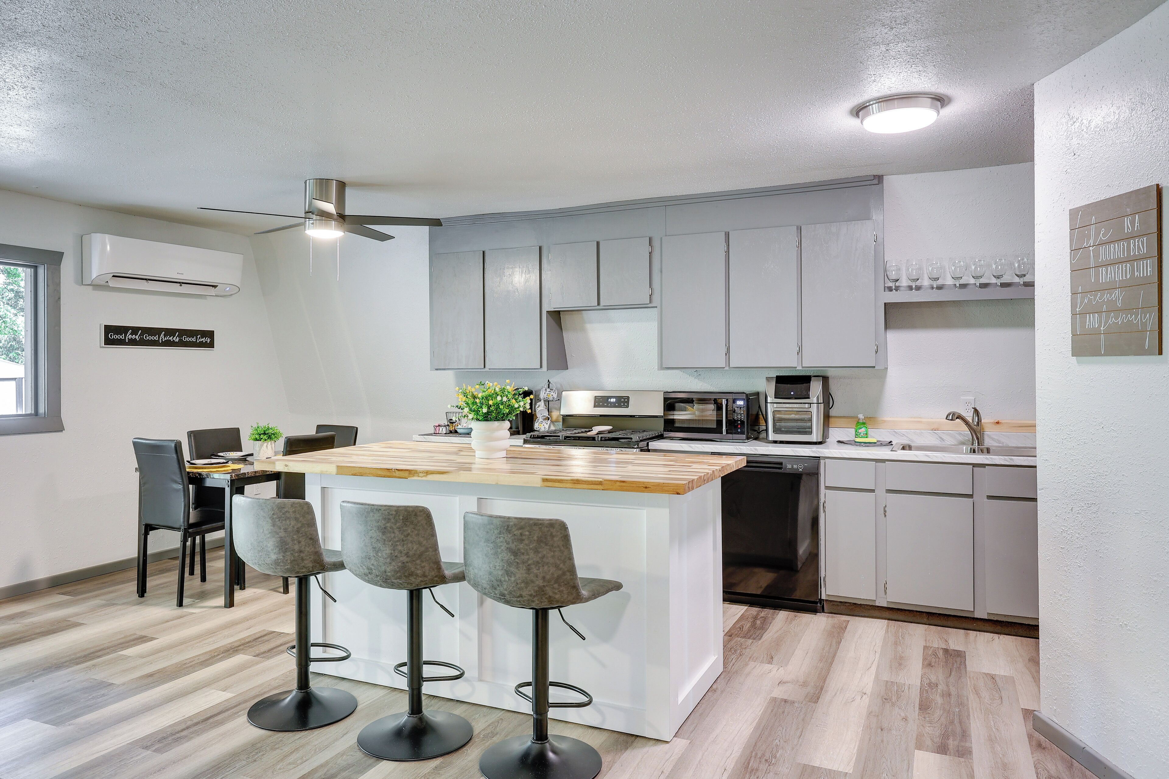 A modern kitchen with a central island, bar stools, and a dining area with chairs.