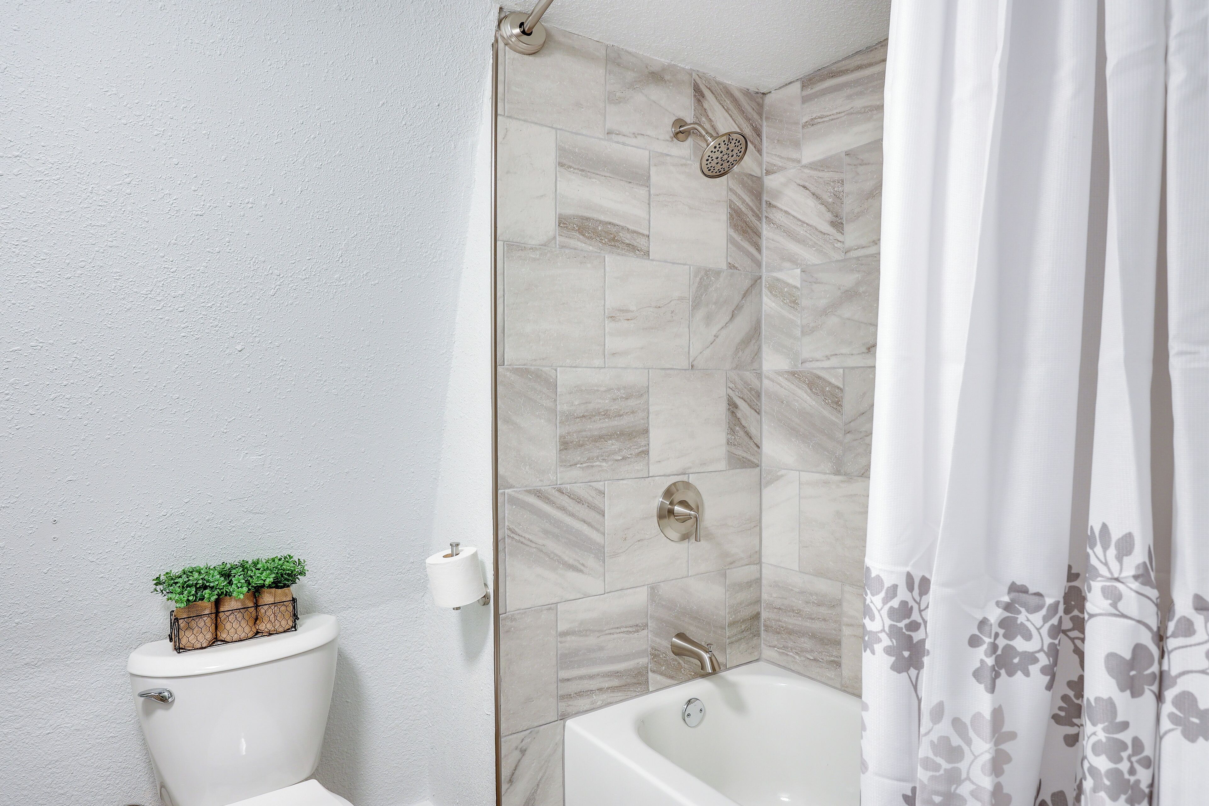 Ein Badezimmer mit Toilette, Dusche und Badewanne.