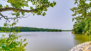Un lac paisible, bordé d’une rive rocheuse et entouré d’une végétation luxuriante.