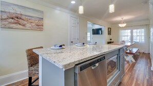 A modern kitchen with a granite countertop, stainless steel appliances, and pendant lighting. - Walk to Water: Coastal-chic Home Near Myrtle Beach (North Myrtle Beach)