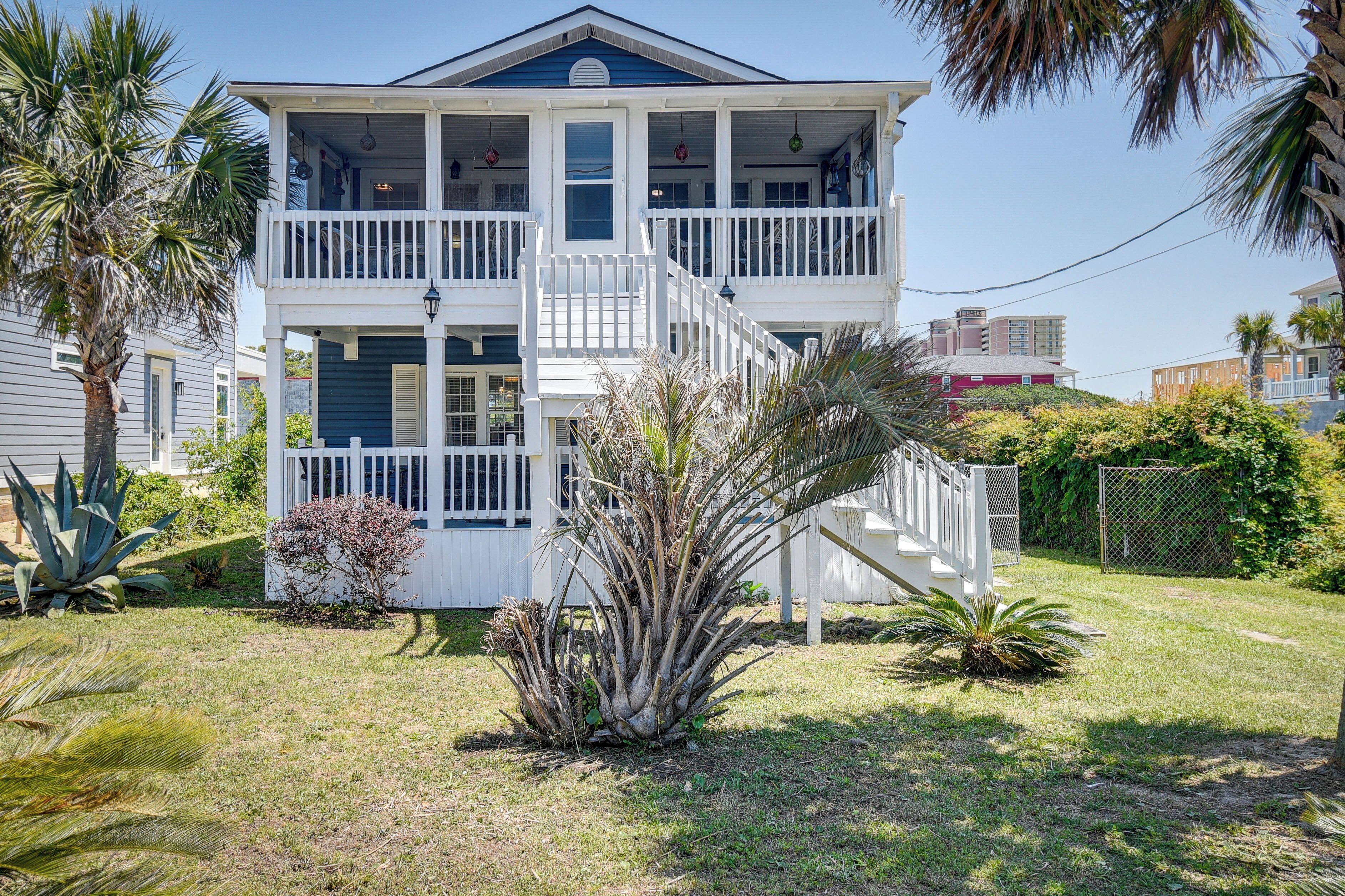 A two-story house with a balcony, a front porch, and a staircase leading to the upper floor.