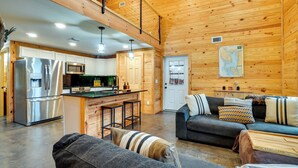 Ein modernes Blockhaus-Interieur mit Küche, Essbereich und Wohnzimmer.