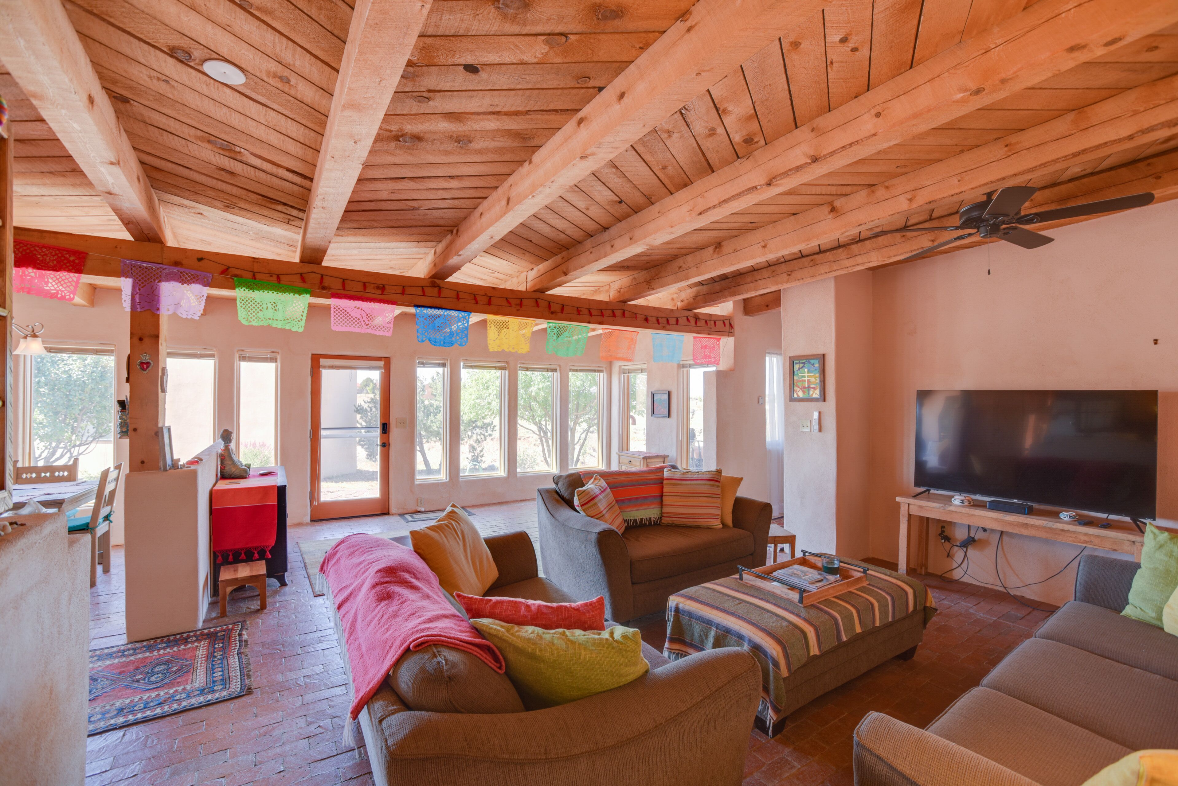 A spacious living room with wooden beams, a large TV, and a cozy seating area.