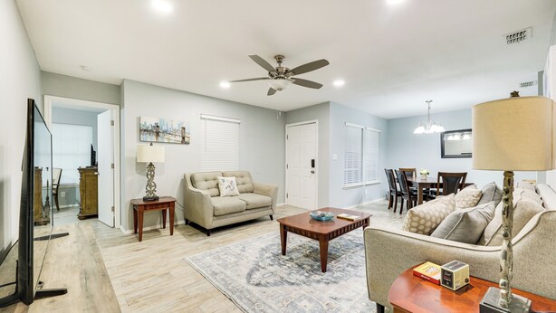 A spacious living room with a ceiling fan, a coffee table, a sofa, and a dining area with chairs and a table. - Fenced Yard & Grill: San Juan Vacation Rental! (San Juan)