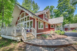 A red house with a porch and a brick pathway. - Lakefront Michigan Retreat w/ Private Dock (Channing)