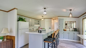 A modern kitchen with a central island, bar stools, and a refrigerator. - Fire Pit + Deck: Peaceful Silver Creek Retreat (Silver Creek)
