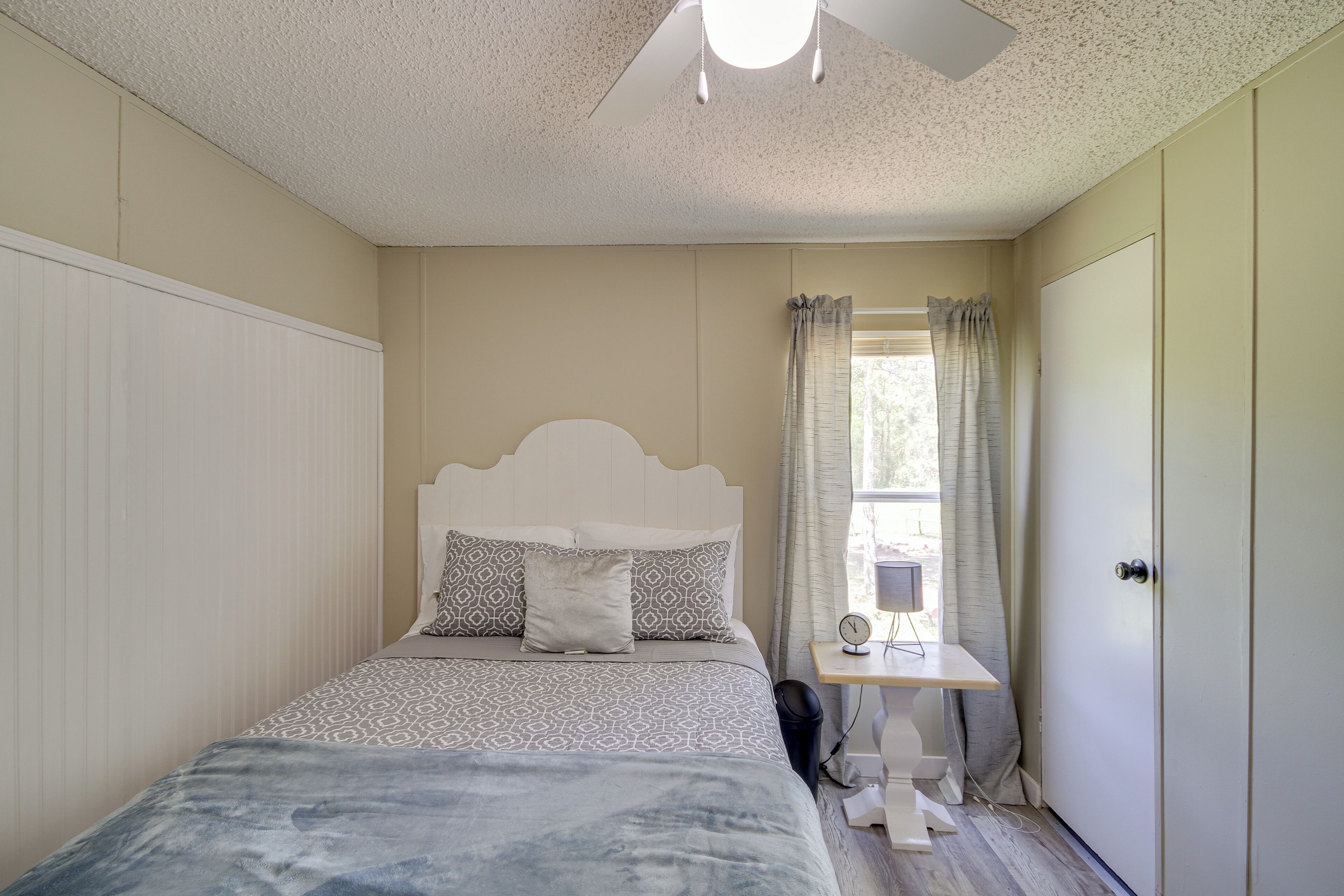 A bedroom with a bed, bedside table, and a wardrobe.