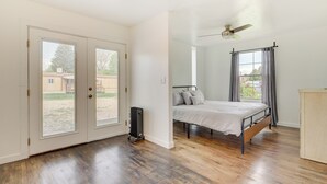 Une chambre à coucher avec un lit, un ventilateur de plafond et une vue par la fenêtre.