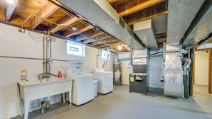 A laundry room with washing machines, a sink, and a water heater. - Top-floor Wyandotte Apt Near Detroit Riverfront! (Wyandotte)