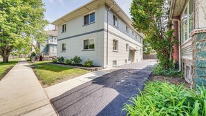 A two-story residential building with a front porch, a driveway, and a sidewalk. - Top-floor Wyandotte Apt Near Detroit Riverfront! (Wyandotte)