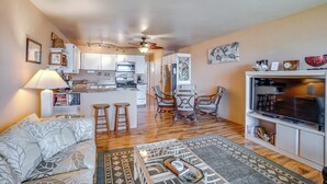 Un apartamento moderno con sala de estar, comedor, cocina y zona de televisión.