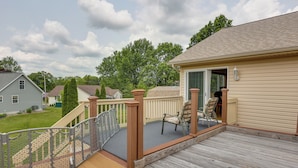 A wooden deck with a railing, a chair, and a door leading to a covered area. - Wfh-friendly Columbiana Vacation Rental w/ Deck! (Columbiana)