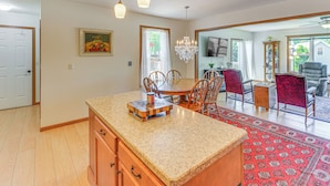 A spacious kitchen with a granite countertop, wooden cabinets, and a dining area with a chandelier. - Wfh-friendly Columbiana Vacation Rental w/ Deck! (Columbiana)