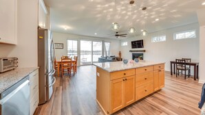 A spacious kitchen with a large island, wooden cabinets, and a built-in dishwasher. - Lakefront Burlington Vacation Rental: Dock + Beach (Burlington)