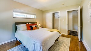 A bedroom with a bed, a nightstand, a window with blinds, a closet, and a door. - Wyandotte Vacation Rental Apartment Near Hospital! (Wyandotte)