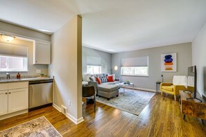 Relax in this stylish living space with a fully equipped kitchen, comfortable seating area, and large rug.