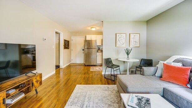 A modern living room with a flat-screen TV, a grey sofa, and a coffee table. - Wyandotte Vacation Rental Apartment Near Hospital! (Wyandotte)