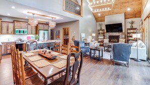 A spacious living area with a dining table, chairs, a fireplace, and a television. - Gorgeous Drasco Home Near Greers Ferry Lake! (Drasco)