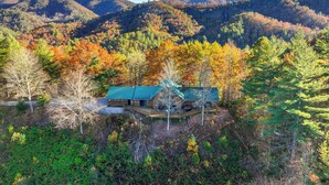A cabin with a green roof, surrounded by autumn foliage and mountains. - Almond Vacation Rental w/ Mountain Views! (Almond)