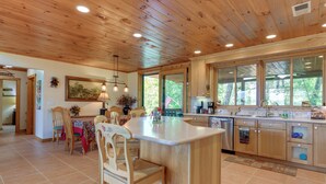 A spacious kitchen with wooden cabinets, a large island, and a dining area with chairs and a table. - Almond Vacation Rental w/ Mountain Views! (Almond)