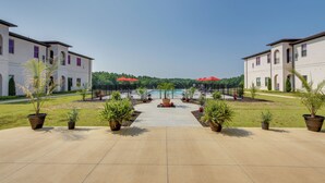 A courtyard with a pool, potted plants, and two buildings with arched windows. - Keestone Resort Apartment ~ 7 Mi to State Park (Loretto)