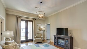A living room with a sofa, a television, a cabinet, a chair, and a patterned rug. - Keestone Resort Apartment ~ 7 Mi to State Park (Loretto)
